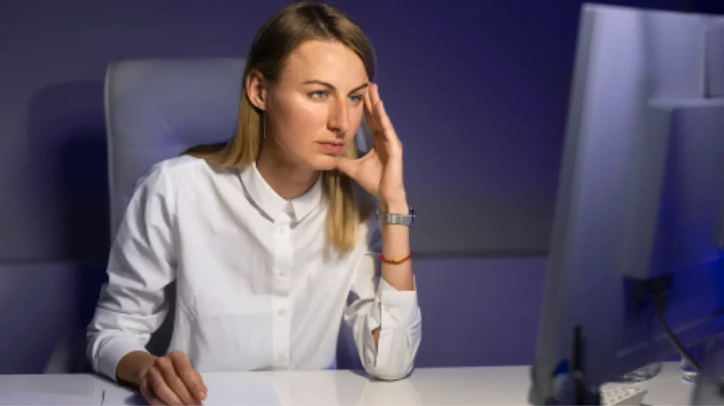 Concerned woman reviews fiduciary responsibility policy for PBM services on computer.