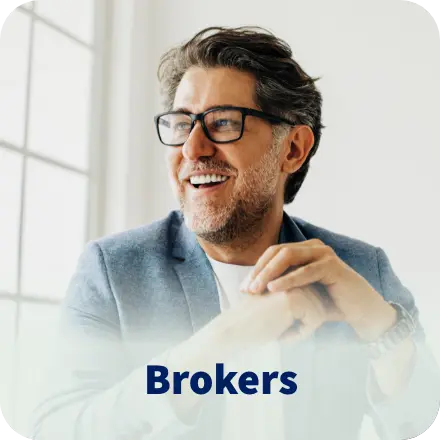 Smiling man with glasses wearing a blazer. Brokers.
