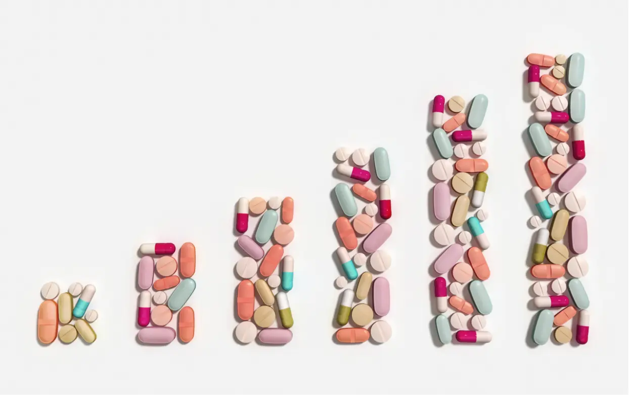 solutions-hero Solutions: Bar graph made of pills and capsules on white background. Pharmacy, medicine, and healthcare concept.